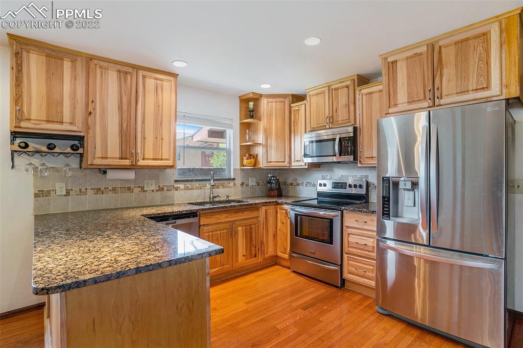4810 Airport Road Colorado Springs, CO 80916 - Photo 10 of 41 a kitchen with stainless steel appliances granite countertop a refrigerator stove microwave and sink
