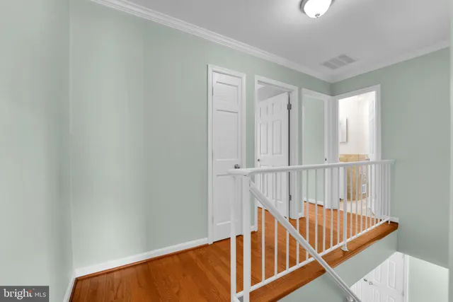 a view of staircase with wooden floor and white walls