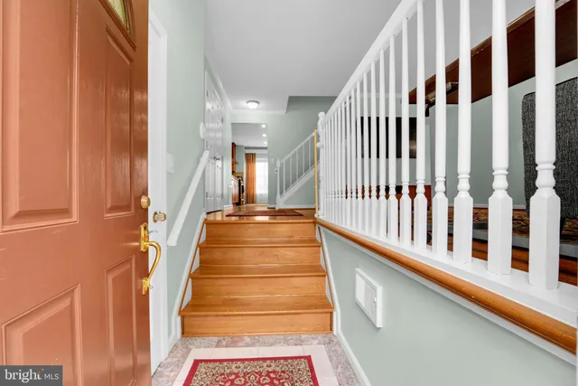 a view of staircase with lots of frames on wall and a window