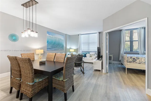 a dining room with furniture a chandelier and wooden floor