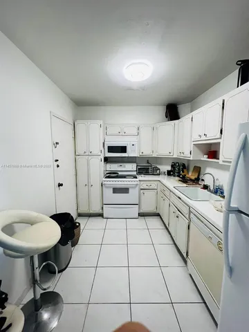 a kitchen with a white cabinets and white appliances