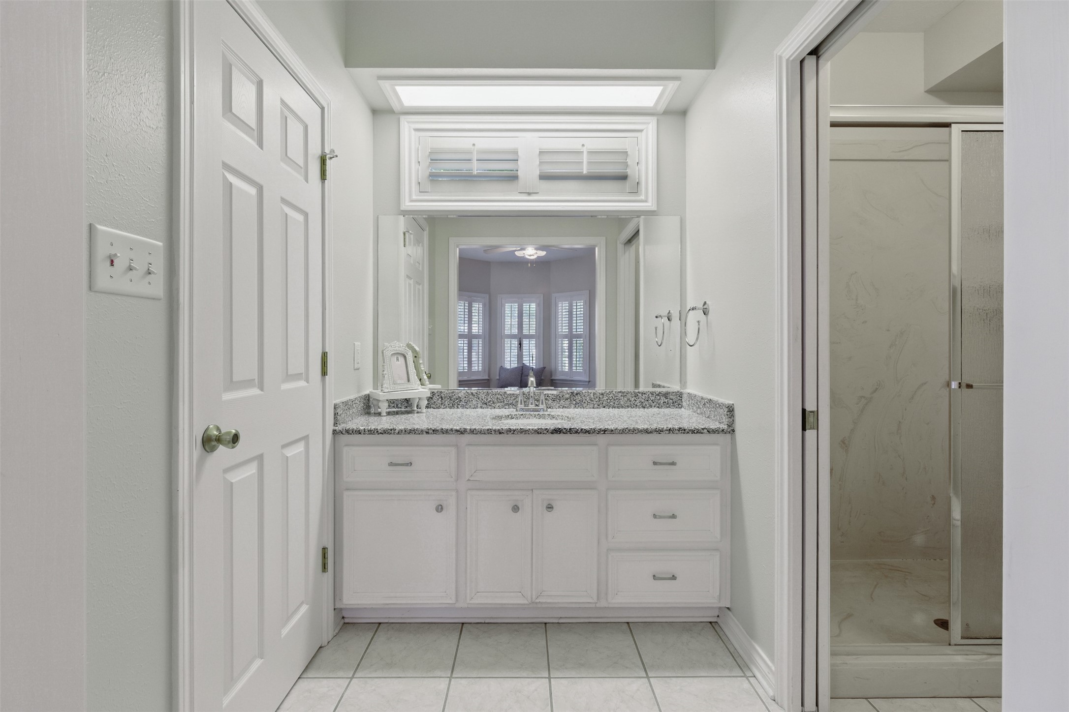 407 West Main Street Brenham, TX 77833 - Photo 22 of 50 a bathroom with a granite countertop sink a mirror and a vanity