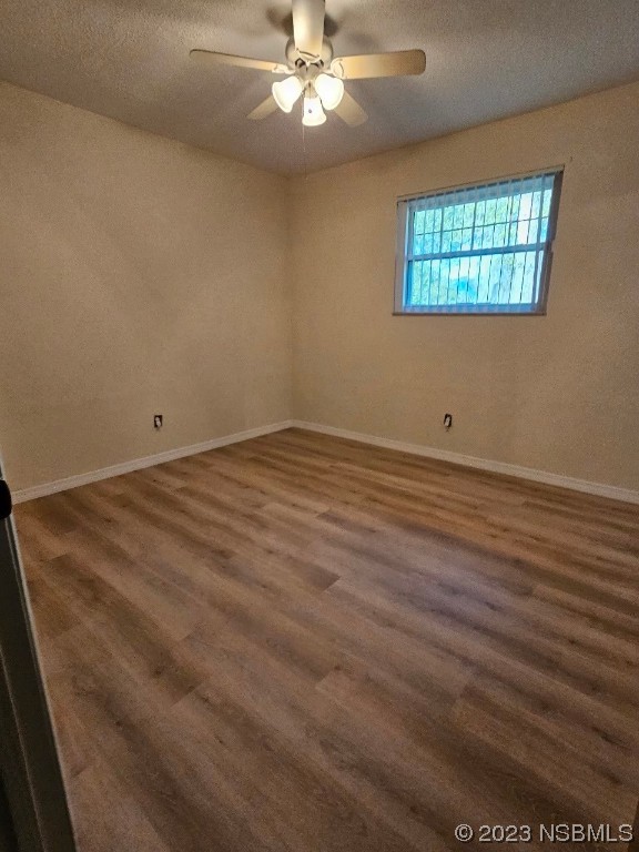 2410 Lime Tree Drive Edgewater, FL 32141 - Photo 8 of 18 an empty room with wooden floor chandelier fan and windows