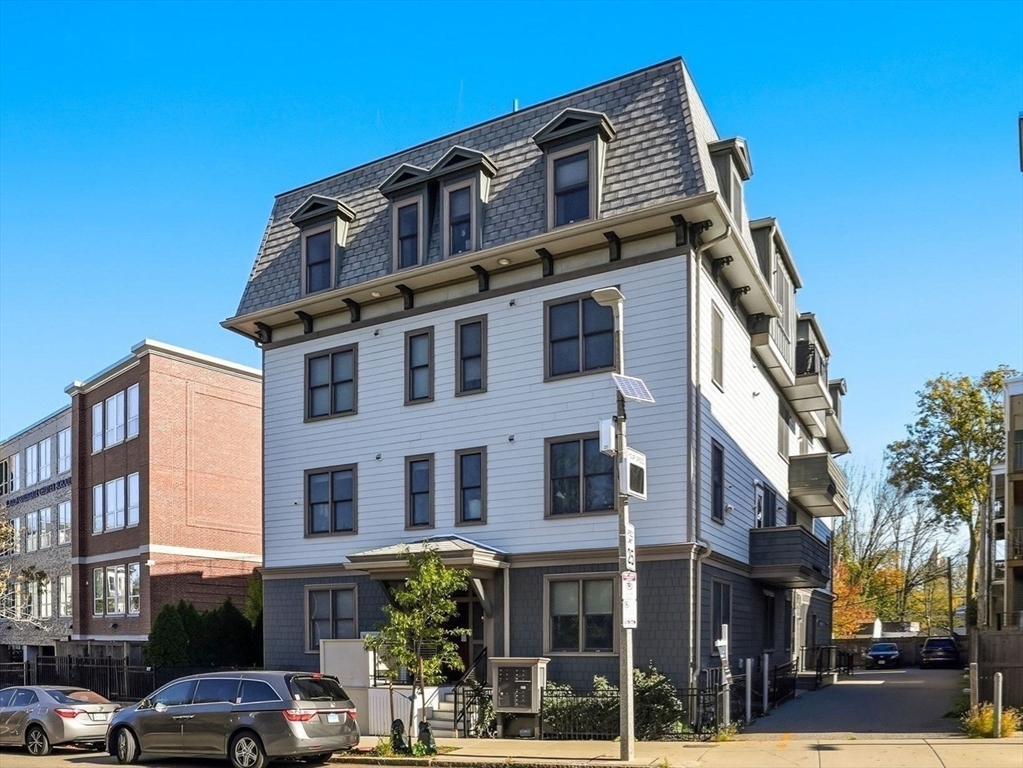 246 Boston Street, Unit 9 Boston, MA 02125 - Photo 22 of 24 a front view of a building with lot of cars and trees