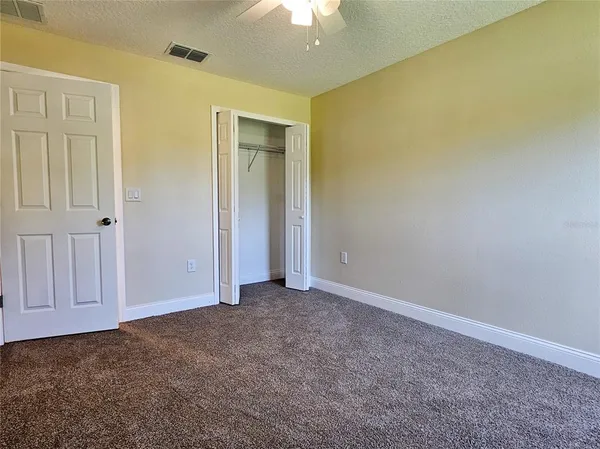 an empty room with a ceiling fan and a window