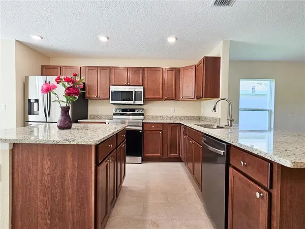 a kitchen with a sink stove top oven and microwave