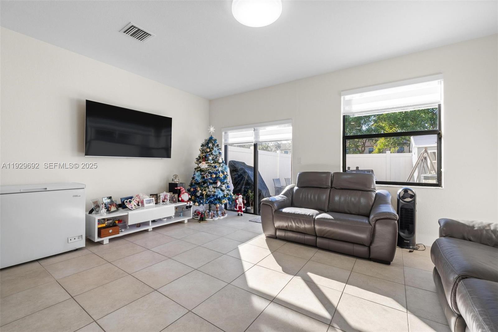 3272 West 92nd Place Hialeah, FL 33018 - Photo 12 of 37 a living room with furniture a flat screen tv and a window