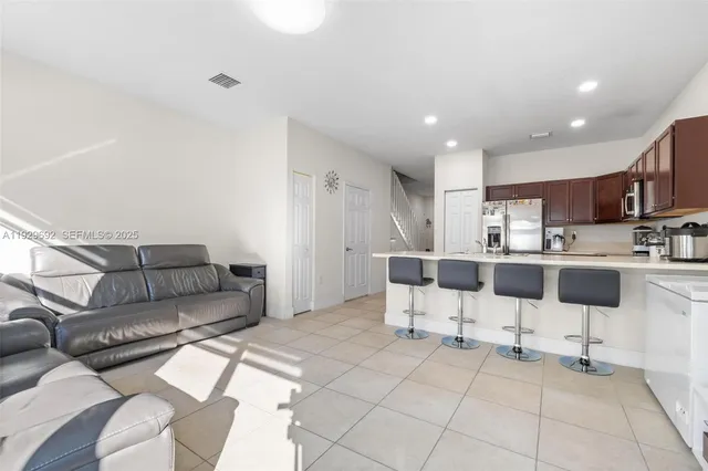 a living room with furniture and kitchen view