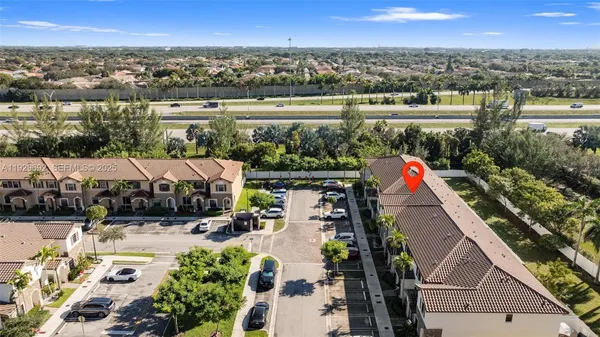an aerial view of multiple houses with a yard