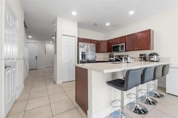 a kitchen with kitchen island granite countertop a sink and a refrigerator