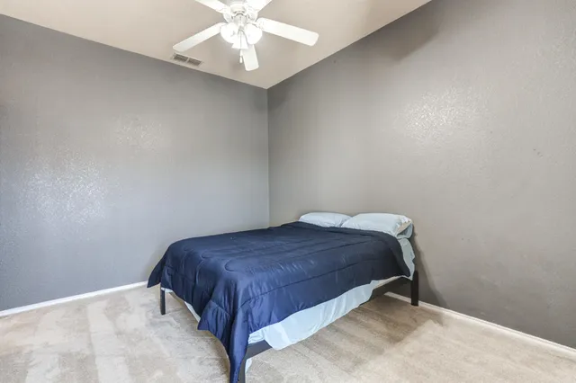 a bed sitting in a bedroom next to a window