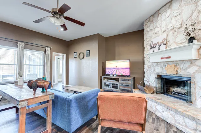 a living room with furniture a flat screen tv and a fireplace