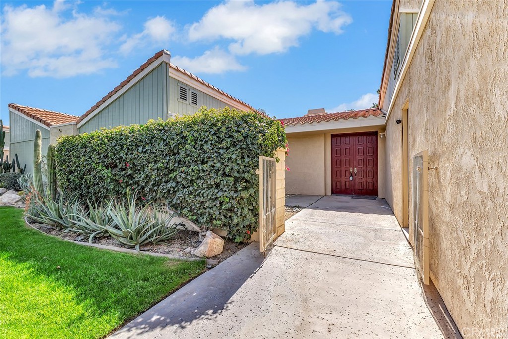 72355 Roxbury Drive Rancho Mirage, CA 92270 - Photo 11 of 61 a front view of a house with a garden and plants