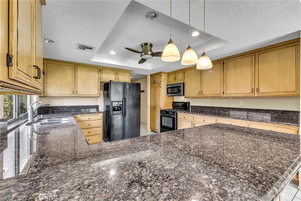 72355 Roxbury Drive Rancho Mirage, CA 92270 - Photo 27 of 61 a kitchen with granite countertop a refrigerator a stove top oven a sink and dishwasher
