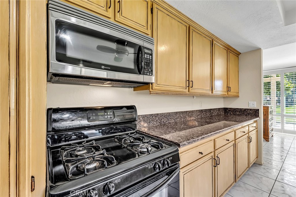 72355 Roxbury Drive Rancho Mirage, CA 92270 - Photo 31 of 61 a kitchen with granite countertop a stove and a microwave