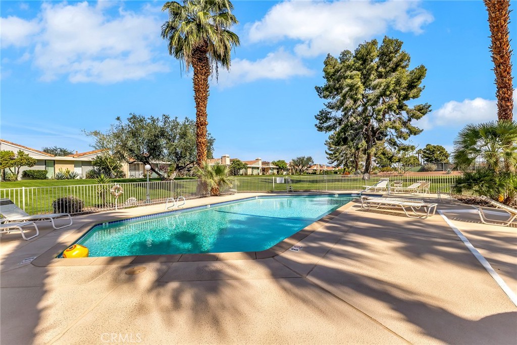 72355 Roxbury Drive Rancho Mirage, CA 92270 - Photo 54 of 61 a view of a swimming pool with a lawn chairs under an umbrella