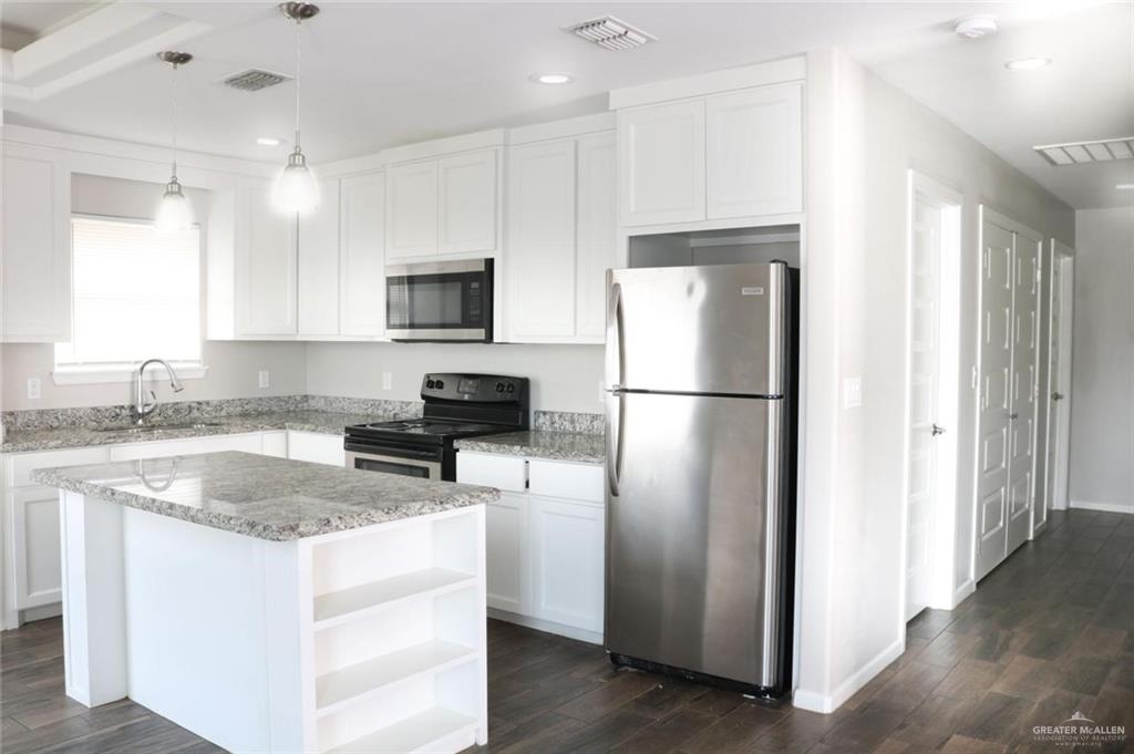 701 Cathedral Hill, Unit 1 Edinburg, TX 78541 - Photo 2 of 14 Kitchen with open shelves, stainless steel appliances, white cabinetry, light stone countertops, and recessed lighting