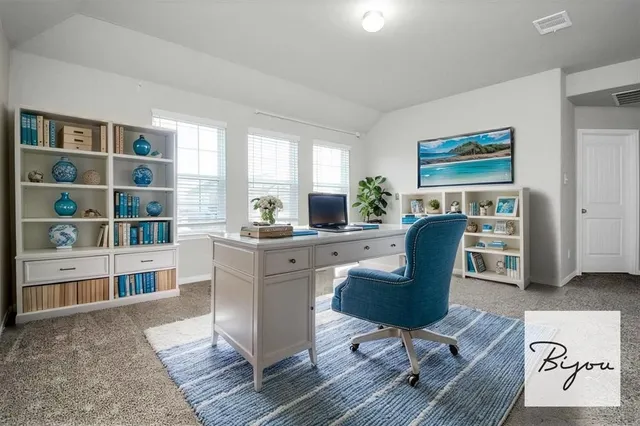 a view of a workspace with furniture and a window