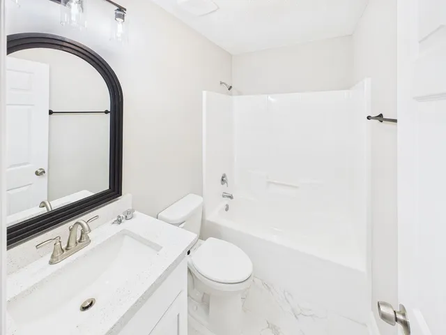 a bathroom with a sink a toilet and a mirror