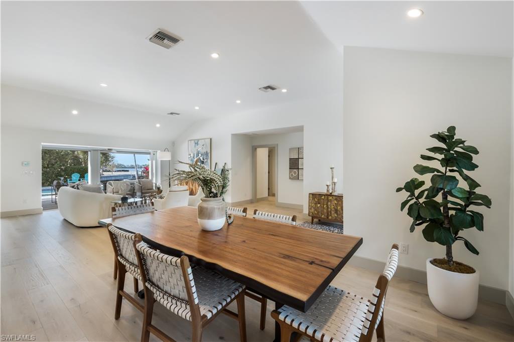 5215 Seashell Avenue Naples, FL 34103 - Photo 15 of 47 a dining room with furniture potted plants and wooden floor