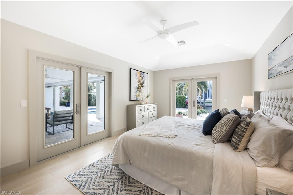 5215 Seashell Avenue Naples, FL 34103 - Photo 17 of 47 a bedroom with a large bed and a chandelier