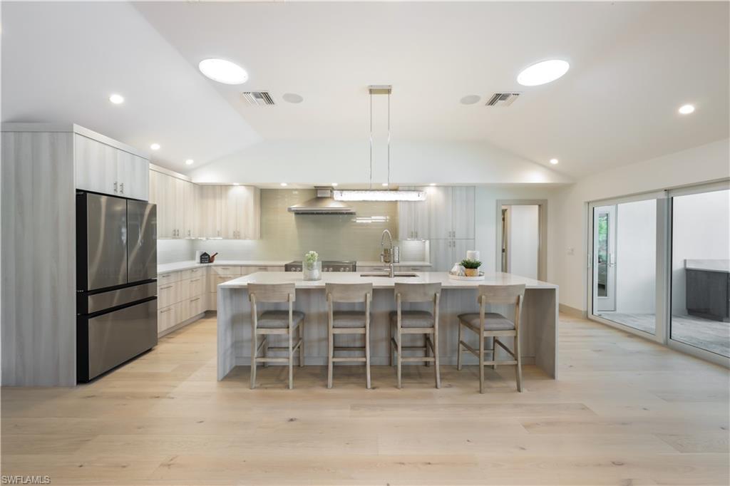 a kitchen with a dining table chairs and refrigerator