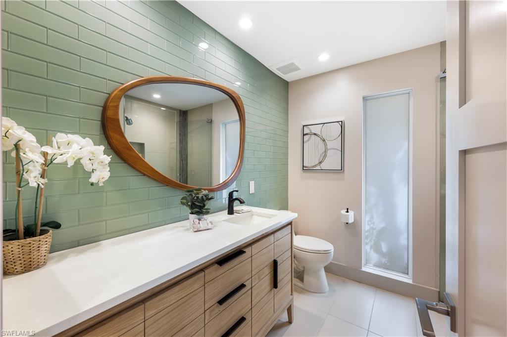 5215 Seashell Avenue Naples, FL 34103 - Photo 20 of 47 a bathroom with a toilet a sink and mirror