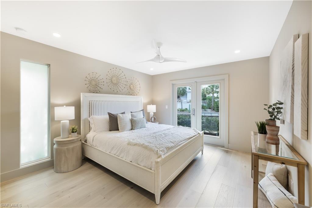 5215 Seashell Avenue Naples, FL 34103 - Photo 21 of 47 a bedroom with a large bed and a large window