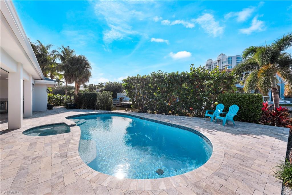 5215 Seashell Avenue Naples, FL 34103 - Photo 29 of 47 a view of a swimming pool with sitting area