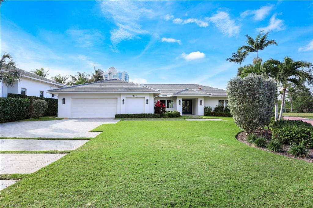 5215 Seashell Avenue Naples, FL 34103 - Photo 40 of 47 a front view of a house with a yard and garage