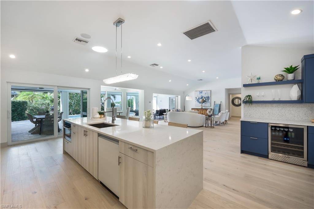 5215 Seashell Avenue Naples, FL 34103 - Photo 6 of 47 a kitchen with stainless steel appliances granite countertop a sink and dishwasher with wooden floor