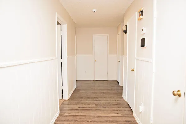 a view of a hallway with wooden floor