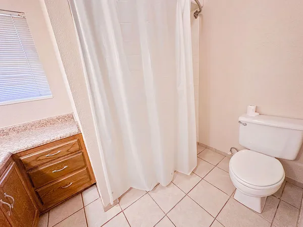 a bathroom with a toilet and a shower curtain