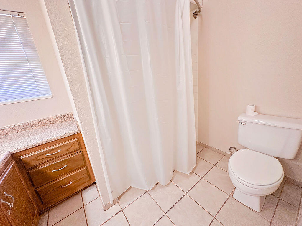 1410 2nd Street Plains, TX 79355 - Photo 35 of 35 a bathroom with a toilet and a shower curtain