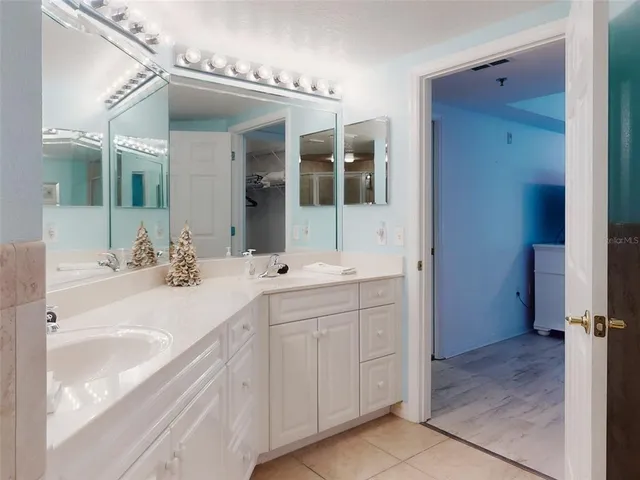 a kitchen with stainless steel appliances granite countertop a dining table chairs refrigerator and sink