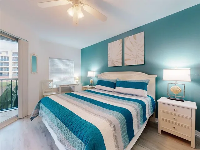 a view of pool with lawn chairs and large trees