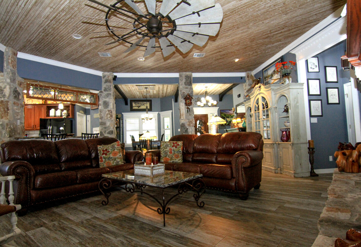 219 Young Ranch Road Georgetown, TX 78633 - Photo 3 of 40 Living area featuring stone columns, a windmill fan, crown molding, wood ceiling, and tile floors