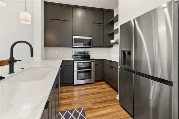 a kitchen with stainless steel appliances granite countertop a refrigerator and a sink