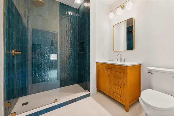 a bathroom with a granite countertop sink toilet and shower