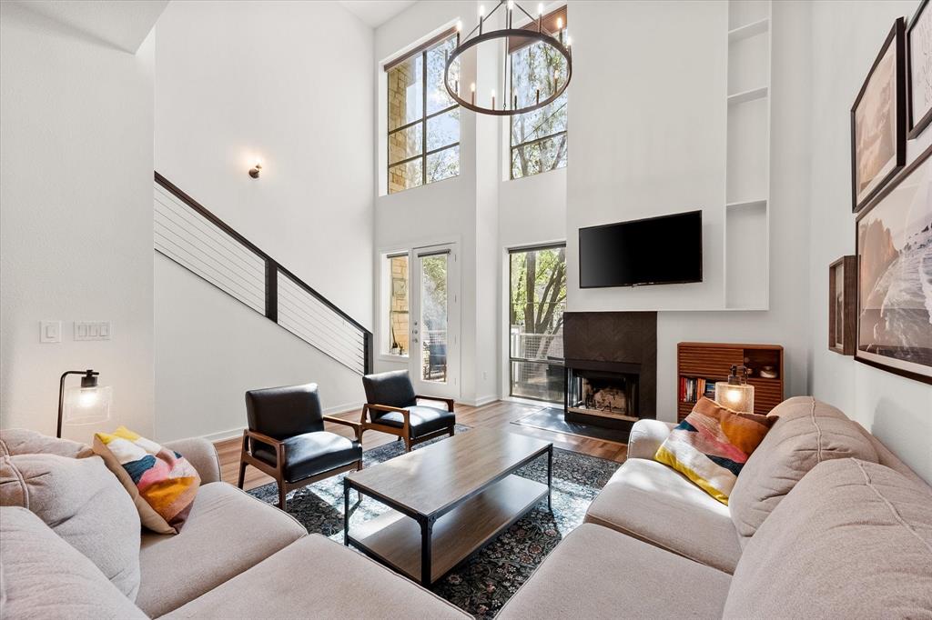 6907 Sumner Street The Colony, TX 75056 - Photo 10 of 35 Gorgeous living room complete with floor to ceiling windows and a wood burning fireplace.