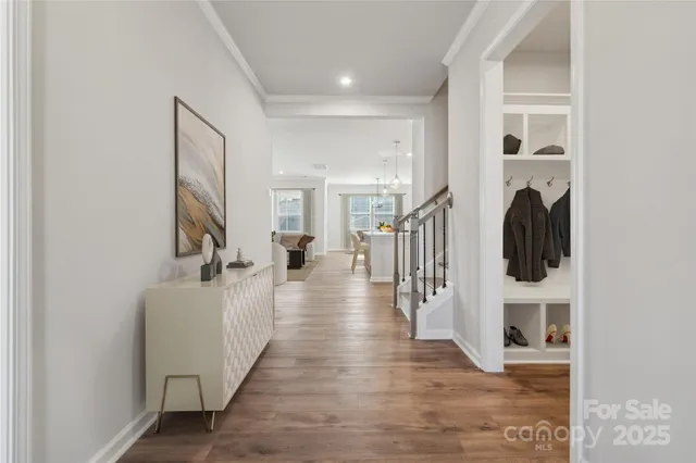 a hallway with a view of living room with furniture and wooden floor