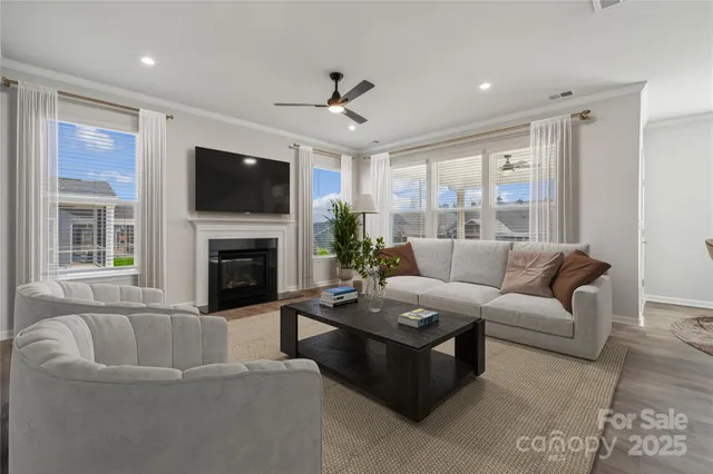 a living room with furniture a flat screen tv and a fireplace