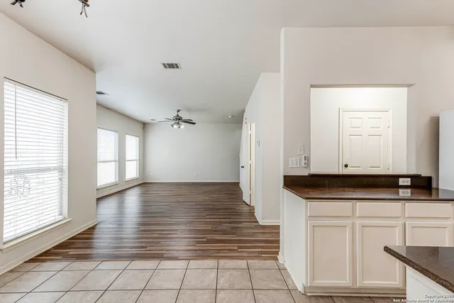 a view of kitchen with granite countertop cabinets and window
