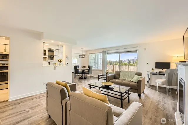 a living room with furniture large window and wooden floor