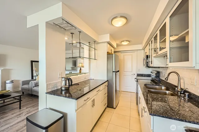 a kitchen with granite countertop a sink and a stove top oven