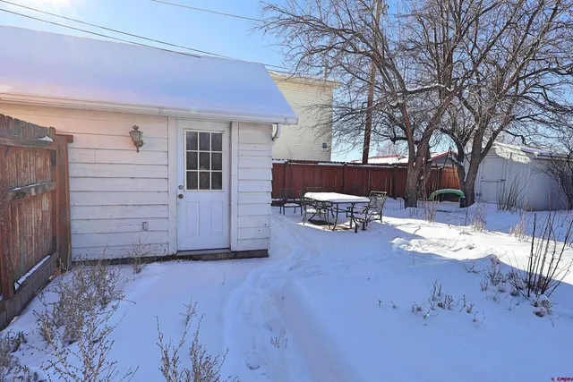 a view of a house with a yard covered in snow