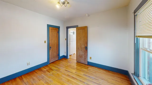 a view of empty room with wooden floor