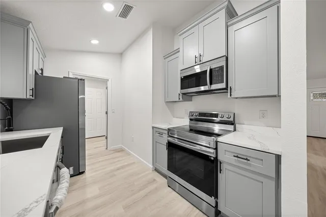a kitchen with stainless steel appliances white cabinets and a stove top oven