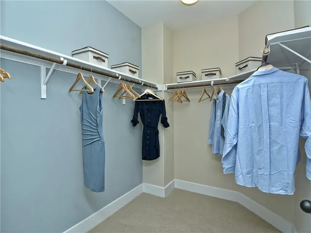 a view of walk in closet with clothes and shoes