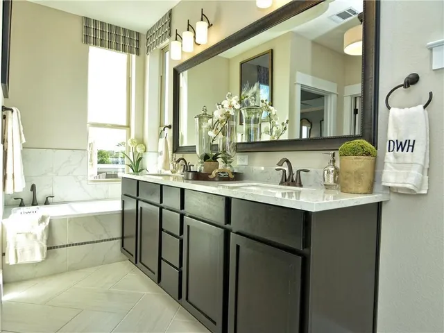 a bathroom with a tub sink and mirror